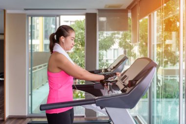 bir kardiyo makinede egzersiz fitness kız ve sabah dinlenmek için müzik