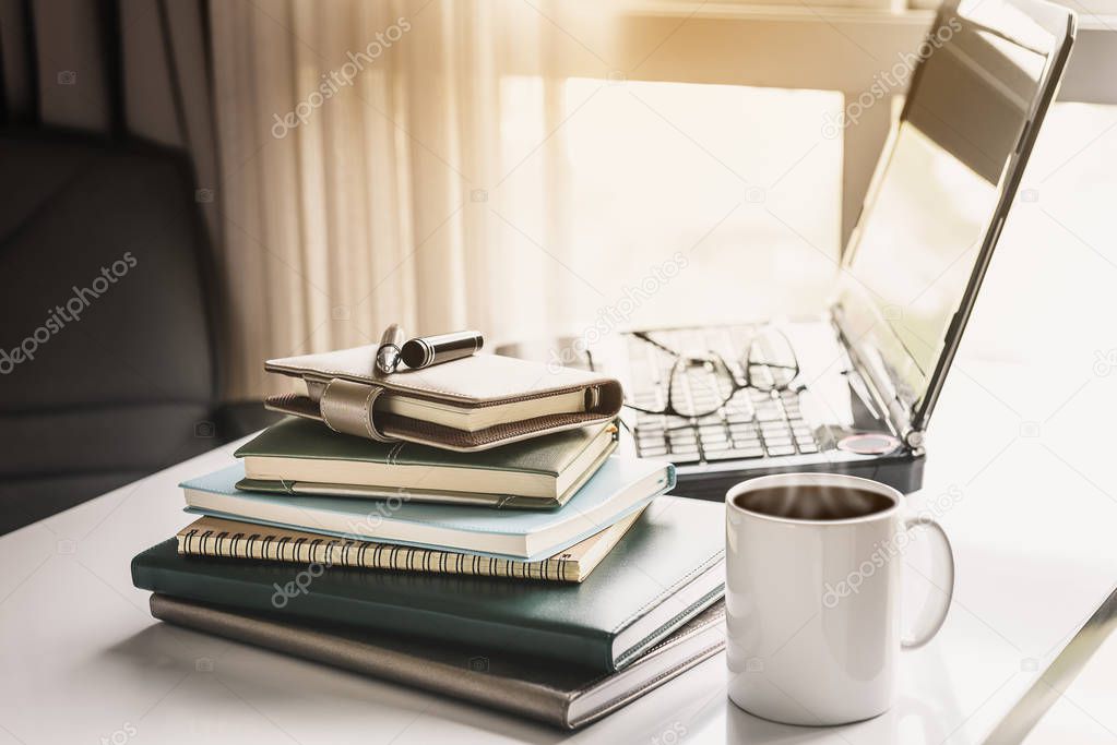 Office workplace with laptop, office equipment and coffee cup on white desk