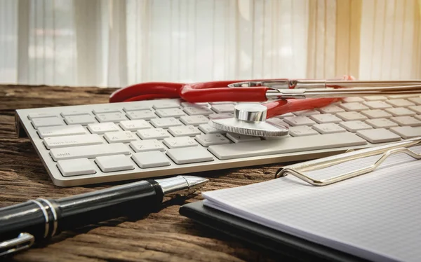 Lugar de trabajo médico con estetoscopio y portapapeles en escritorio de madera — Foto de Stock