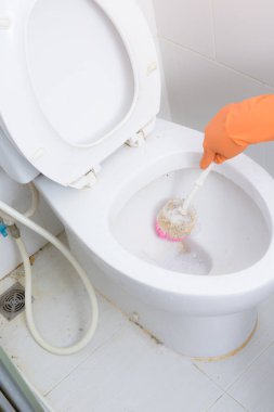 Tuvalet, tuvalet, lavabo fırçası kullanarak Temizleme turuncu eldiven elinde