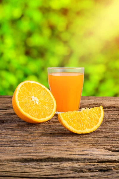 Copo de suco de laranja fresco na mesa de madeira grunge — Fotografia de Stock