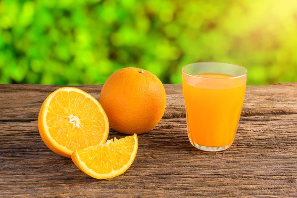 Copo de suco de laranja fresco na mesa de madeira grunge — Fotografia de Stock