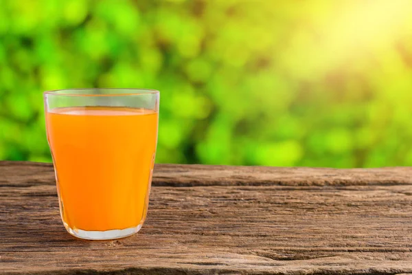 Vidro de suco de laranja fresco na mesa de madeira — Fotografia de Stock