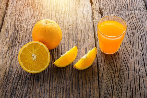 Copo de suco de laranja fresco na mesa de madeira grunge — Fotografia de Stock