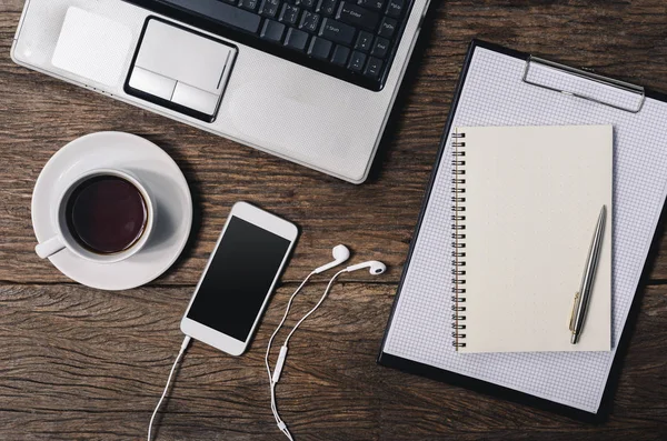 Houten bureau met pen, Kladblok, koffiekopje, smartphone en — Stockfoto