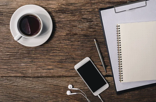 Houten bureau met pen, Kladblok, koffiekopje, smartphone en — Stockfoto