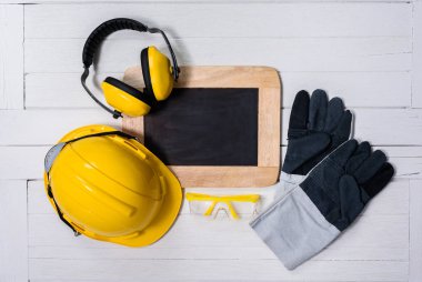 Ahşap masa üzerinde Standart inşaat güvenlik ekipmanları. Üstten Görünüm
