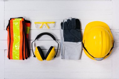 Ahşap masa üzerinde Standart inşaat güvenlik ekipmanları. Üstten Görünüm
