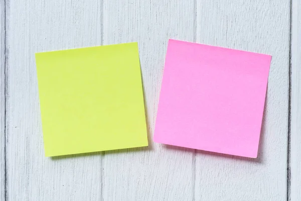 colorful sticky note, post note or post-it on white wooden vinta
