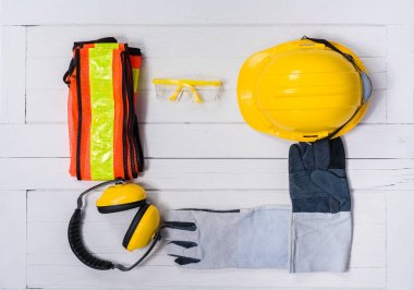 Ahşap masa üzerinde Standart inşaat güvenlik ekipmanları. Üstten Görünüm