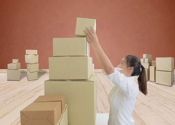 Жінка несе і піднімає коробки — стокове фото