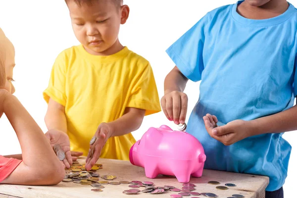 Group of asian children are helping putting coins into piggy ban Stock Image