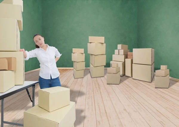 Kvinna som lider av ryggvärk medan du flyttar lådor — Stockfoto