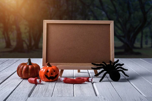 Halloween background. Spooky pumpkin, chalkboard on wooden floor
