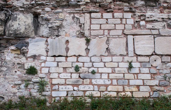 The wall of the Byzantine Palace of Boukoleon, consists of marble blocks, parts and capitals of ancient antique temples. A row of marble blanks of Corinthian capitals of columns embedded in the wall of the Byzantine Palace (Turkey, Istanbul)