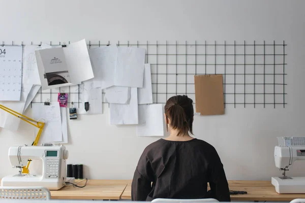 Tailor making a pattern . Sewing machine is standing on the table beside them — Stock Photo, Image