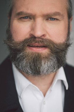 Gri arka planda endişeli bir iş adamının portresi.