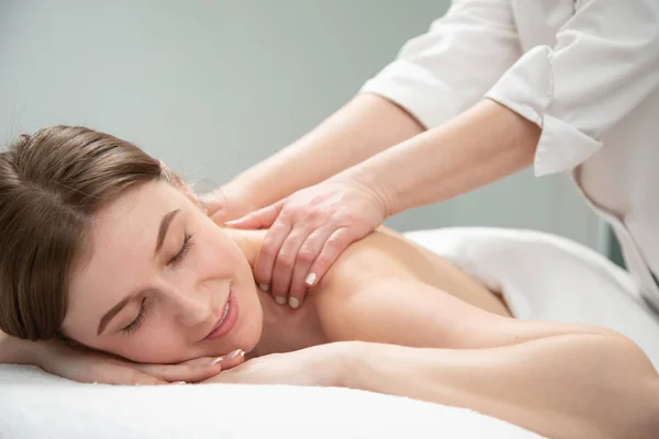 Giovane donna rilassante con massaggio alle mani presso beauty spa. — Foto Stock