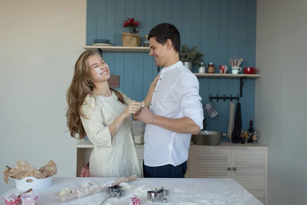 Belo jovem casal está se divertindo na cozinha em casa — Fotografia de Stock