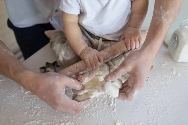 Uma criança com sua mãe na cozinha rola uma massa, produtos da massa, farinha, uma padaria, pão. Master Class. cozinhar e aprender — Fotografia de Stock