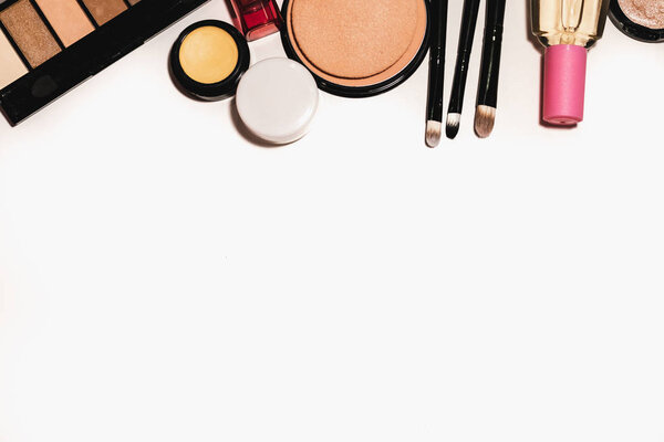 Makeup tools and accessories on a white background with copy space for text. Top view