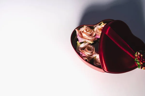 Sevgililer günü arka plan. Beyaz zemin üzerinde bir hediye kutusu çiçeklenir. Boşaltmak.