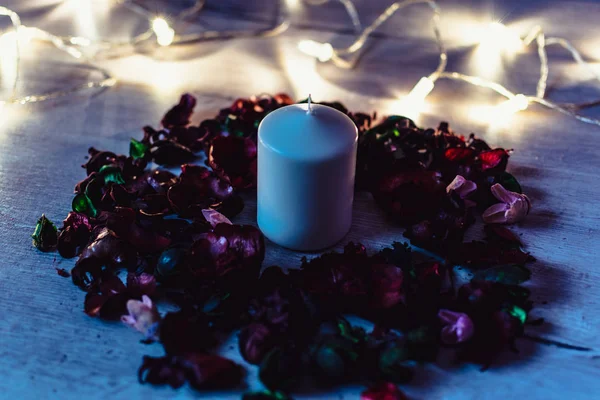 Karanlık romantik arka plan. Çiçekler ve ışıklı mum dekore edilmiş
