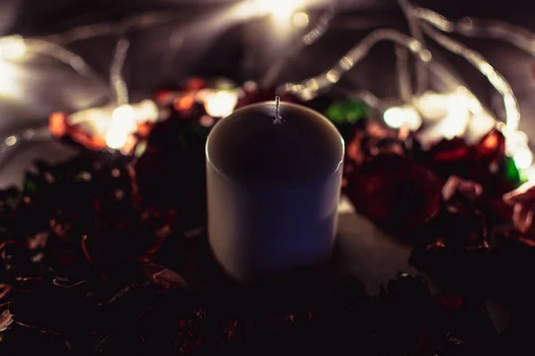 Karanlık romantik arka plan. Çiçekler ve ışıklı mum dekore edilmiş