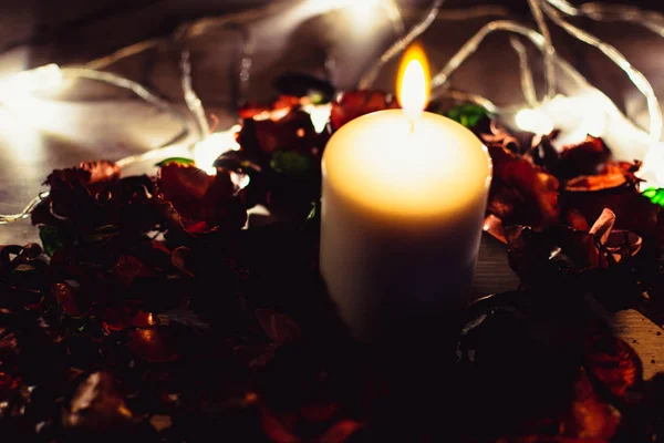 Karanlık romantik arka plan. Çiçekler ve ışıklı mum dekore edilmiş