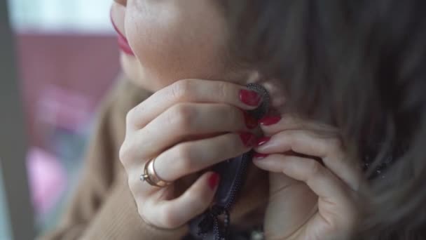 若い女の子が黒いイヤリングを着用 — ストック動画