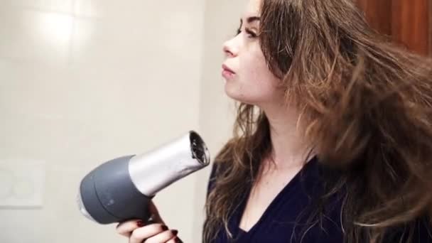 Detailní záběr dívky, která je sušení její dlouhé hnědé vlasy po sprše — Stock video