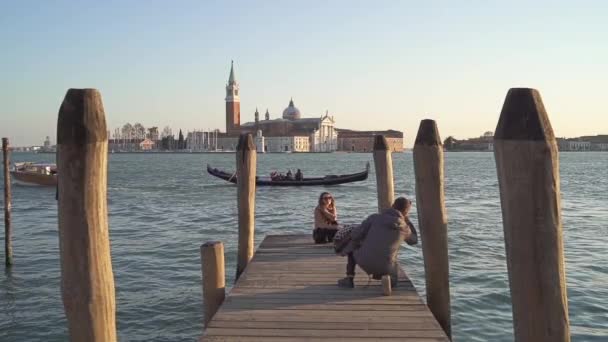 Remote shot van jongen het nemen van foto 's naar een meisje op de achtergrond van baai en vezel — Stockvideo