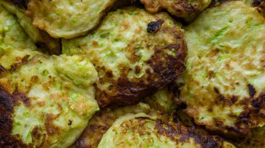 Tavada kızartılmış kabak böreğinin arka planında çıtır çıtır kabuk var.