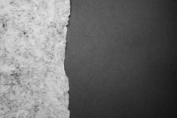 Kullanılmış ıslak mendil, siyah bir yüzeye düz uzanmış, dikey bir çizgi oluşturuyor.