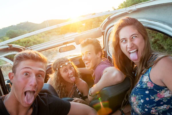 Grupa Szczęśliwych Ludzi Samochodzie Zachodzie Słońca Robiąc Miny — Zdjęcie stockowe