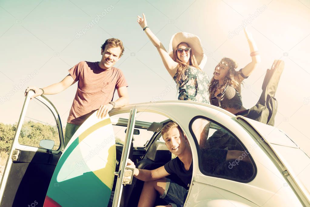 Group of happy people in a car in summertime ready for a roadtrip.