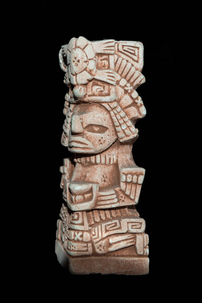 Mayan statue isolated against a black background