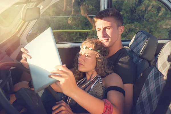 Piękna Młoda Para Patrząca Tablet Samochodzie Przed Zachodem Słońca — Zdjęcie stockowe