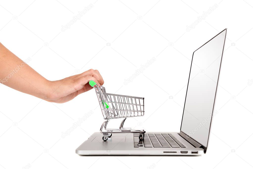 Hand pushing a small shopping cart in a laptop isolated in white