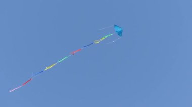 Büyük bir uçurtma mavi gökyüzünde uçar. Gökyüzünde uçan uçurtma.