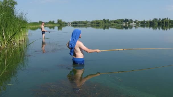 Een Man Met Een Hengel Aan Oever Van Het Meer — Stockvideo