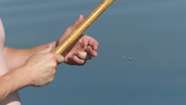 Een Man Met Een Hengel Aan Oever Van Het Meer — Stockvideo