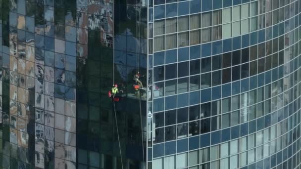 乌克兰基辅 2018年6月 一家清洁公司的员工在清洗摩天大楼的窗户 擦窗器挂在摩天大楼外面的绳子上 — 图库视频影像