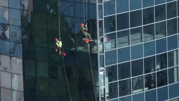 乌克兰基辅 2018年6月 一家清洁公司的员工在清洗摩天大楼的窗户 擦窗器挂在摩天大楼外面的绳子上 — 图库视频影像