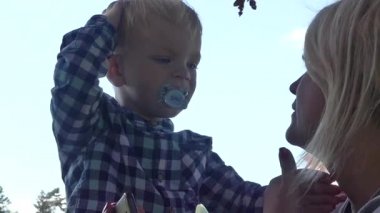 Prag, Çek Cumhuriyeti - 7 Mayıs 2018: Anne ve oğlu kameraya gülümsüyorsun. Bir kızın kollarında iki yaşında bir çocuk.