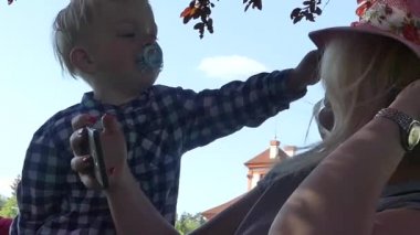 Prag, Çek Cumhuriyeti - 7 Mayıs 2018: Anne ve oğlu kameraya gülümsüyorsun. Bir kızın kollarında iki yaşında bir çocuk.