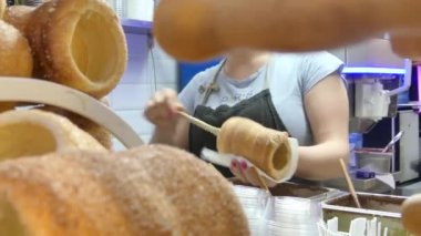 Prag, Çek Cumhuriyeti - 7 Mayıs 2018: Fırın iç insanlar turist turistik Street yürüyüş Prag merkezinde yakınındaki tatlı Trdelnik satın almak
