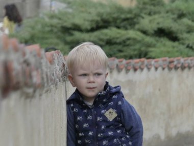 Cesky Krumlov, Çek Cumhuriyeti - 9 Mayıs 2018: eski şehrin arka planı poz iki yaşında bir çocuk