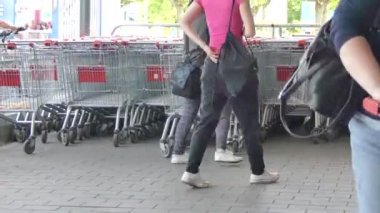 Ceske Budejovice, Çek Cumhuriyeti - 10 Mayıs 2018: Alıcılar bir alışveriş arabası al. Alışveriş sepetlerini piyasada yakınındaki. Alışveriş sepetlerini yakınında mağaza Park edilmiş.