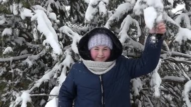 Mutlu genç frolics kış ormanın içinde. Çam ve ona kar Şelalesi şube gerizekalı.